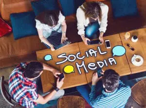 A group of millennials scrolling through and posting on social media sites.